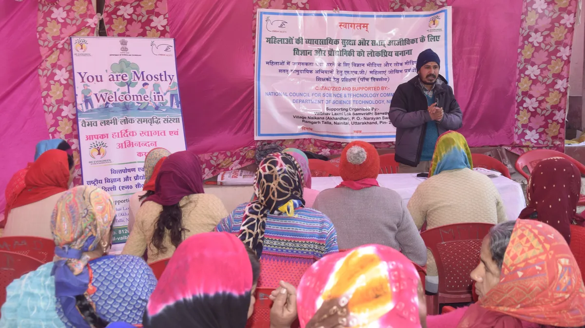 A resource person speaks to seated participants at a science and folk-media session.